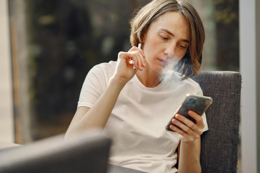 Woman Smoking while Holding Her Phone